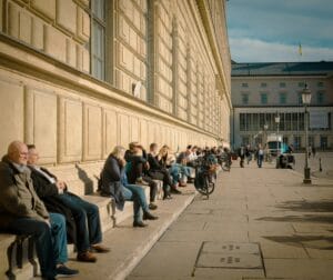 people sitting on a sidewalk