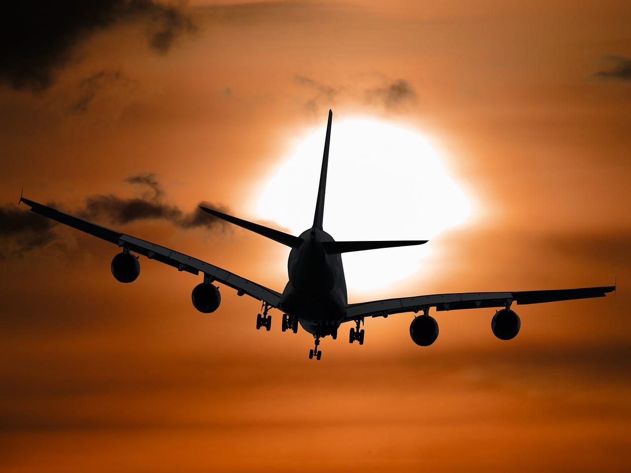airplane flying into the sunset