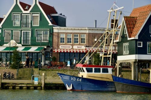 Volendam's iconic harbour. Green and white houses and a fishing boat