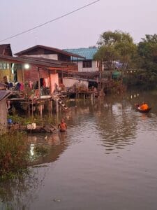 local life in Amphawa. A monk collecting food in the morning and a man taking a bath