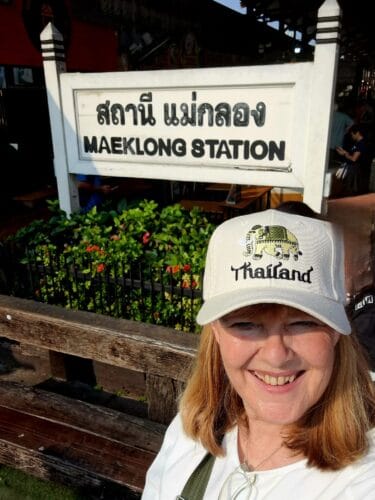 Me standing before the railwaystation sign with a souvenir cap
