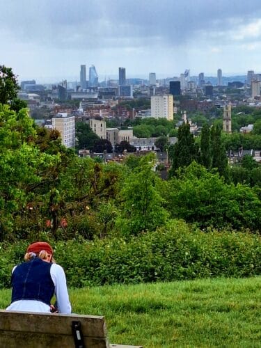 Woman looking at the London view from Parliament hill at Hamstead Heath