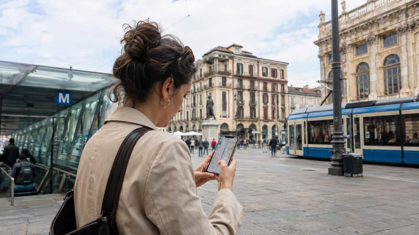 woman checking her phone in a city with a tram