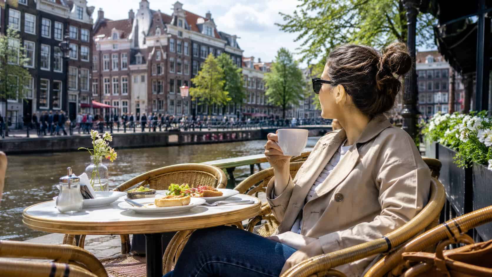 woman enjoying coffee and a view of the city and a river